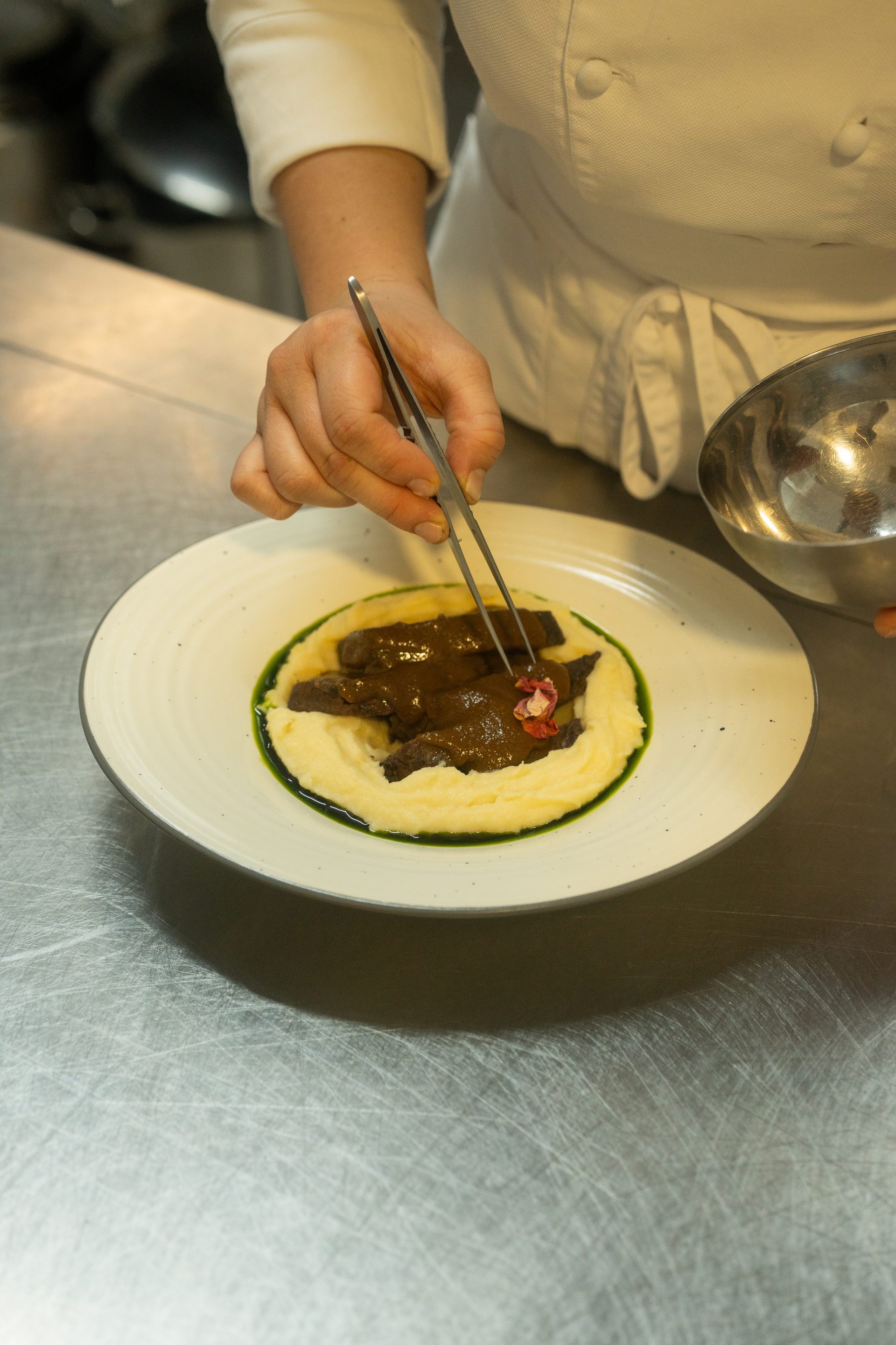 La Ursula chef plating with tweezers — precision and craft