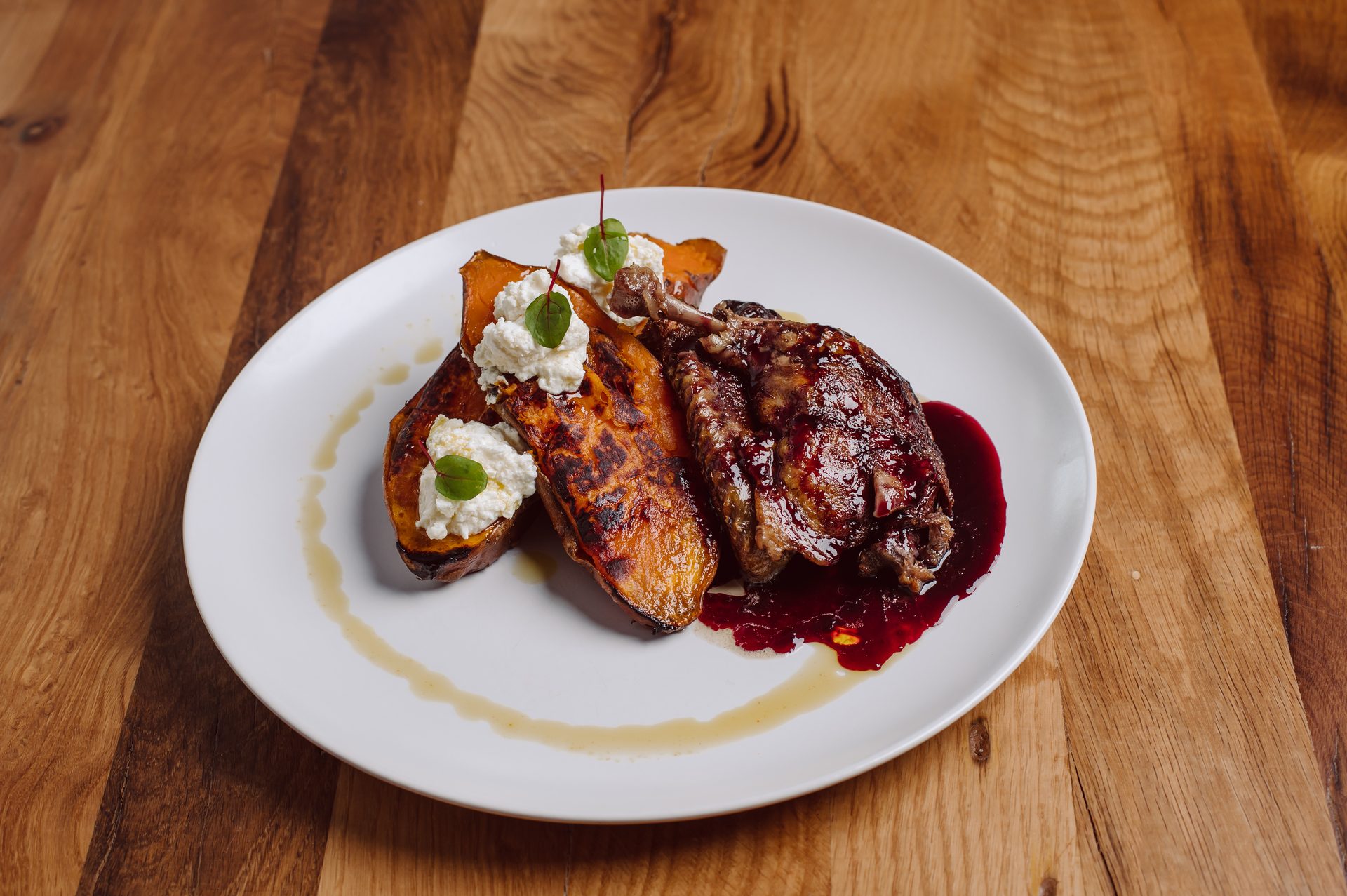 Roasted game bird with cherry sauce, sweet potato and ricotta