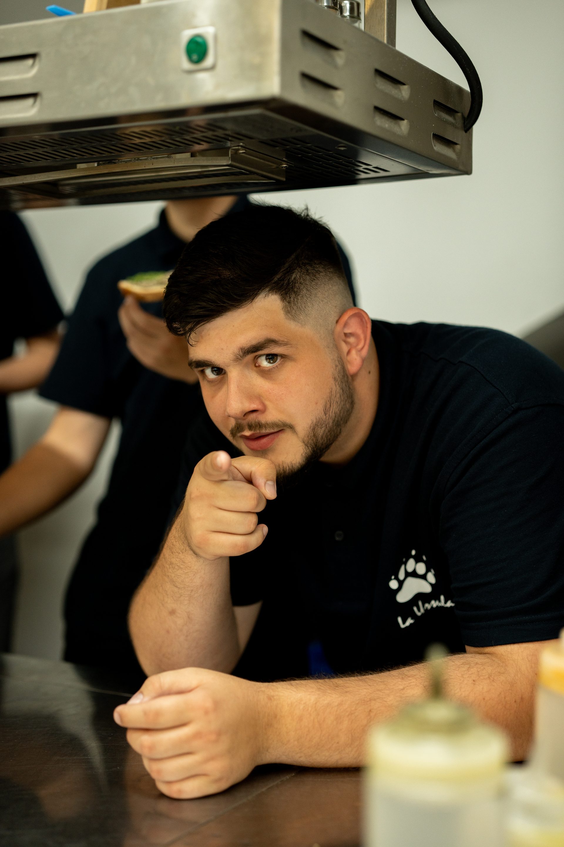 La Ursula chef at the kitchen pass, La Ursula logo on uniform